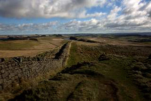Colour landscape image of fluffy white clouds and pathway at Hadrian's Wall.